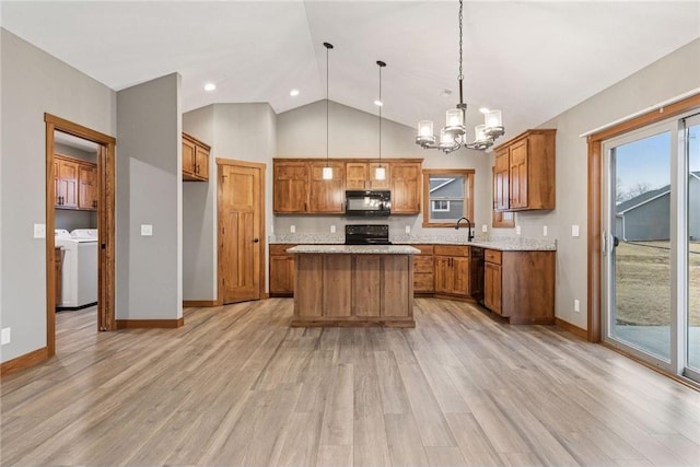 497 Westwood Dr, River Falls, WI 54022 - kitchen featuring brown cabinetry, washing machine and dryer, light countertops, and black appliances
