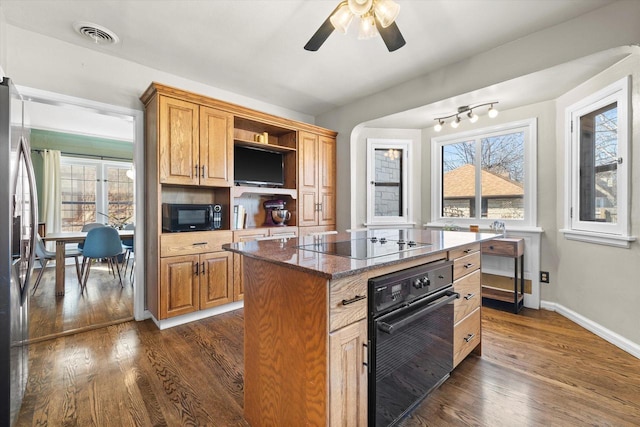 kitchen featuring visible vents, baseboards, black appliances, dark stone countertops, and dark wood finished floors