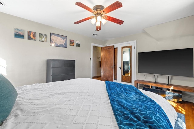 bedroom with ceiling fan, wood finished floors, and visible vents