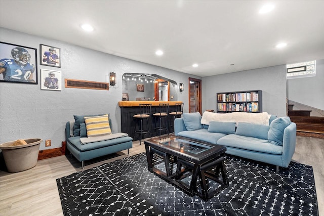 living room featuring a bar, stairway, wood finished floors, and recessed lighting