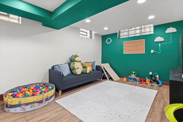 recreation room with a healthy amount of sunlight, wood finished floors, and recessed lighting