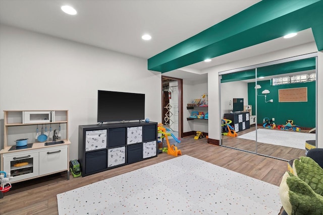 playroom featuring baseboards, wood finished floors, and recessed lighting