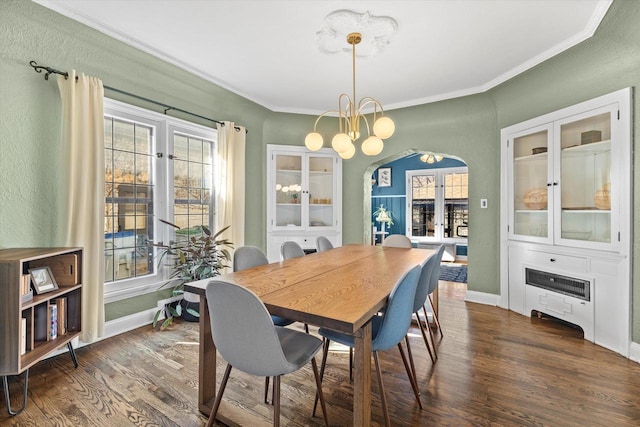 dining room with arched walkways, dark wood-style flooring, a notable chandelier, and crown molding