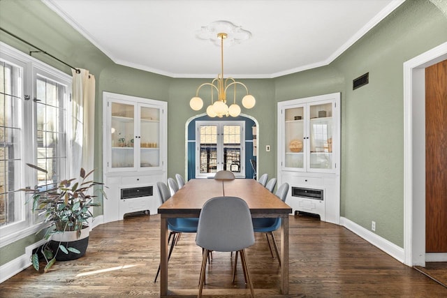 dining area with arched walkways, dark wood finished floors, visible vents, a chandelier, and baseboards