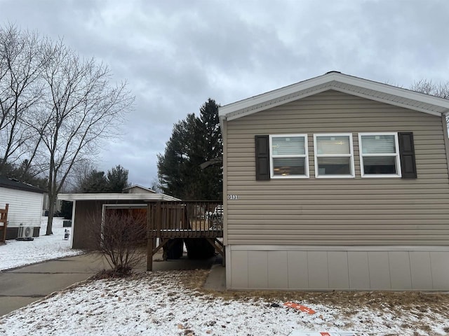 snow covered property with a wooden deck