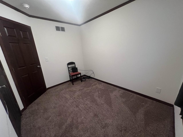 spare room featuring carpet, visible vents, crown molding, and baseboards