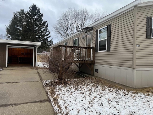 view of property exterior with concrete driveway, crawl space, and a wooden deck