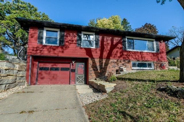 view of front of home featuring driveway, brick siding, and an attached garage