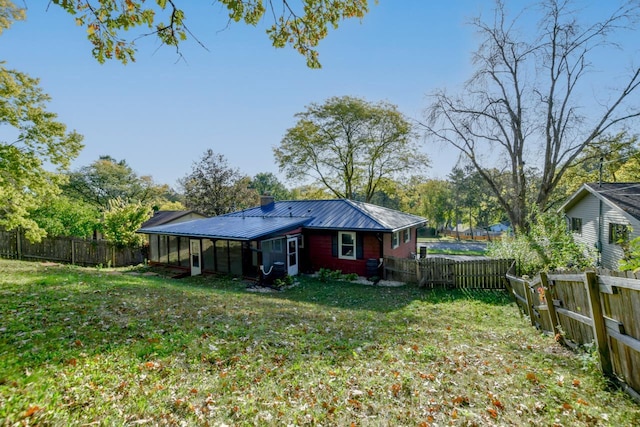 rear view of property featuring a lawn and a fenced backyard