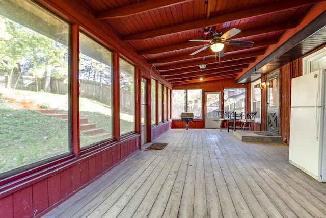 unfurnished sunroom with wood ceiling, a ceiling fan, and beamed ceiling