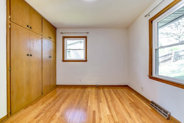 unfurnished bedroom with visible vents, a closet, light wood-style flooring, and baseboards