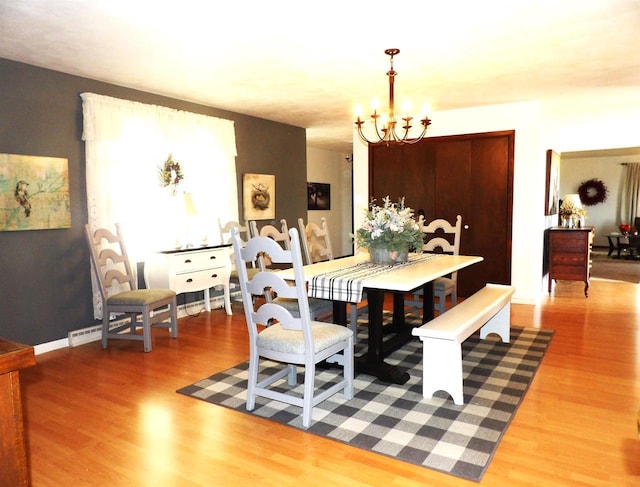 dining room with an inviting chandelier, baseboards, and wood finished floors