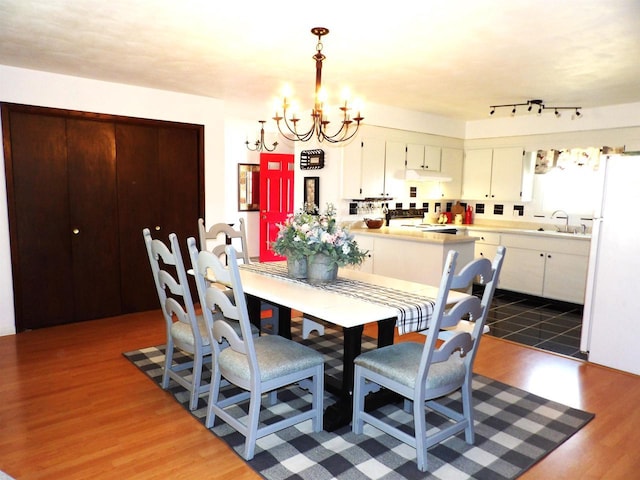 dining area with dark wood-style flooring and an inviting chandelier