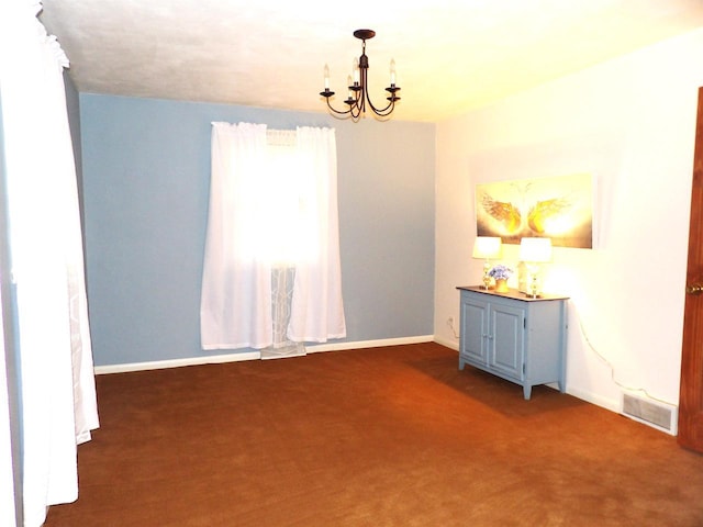 carpeted empty room featuring baseboards, visible vents, and an inviting chandelier