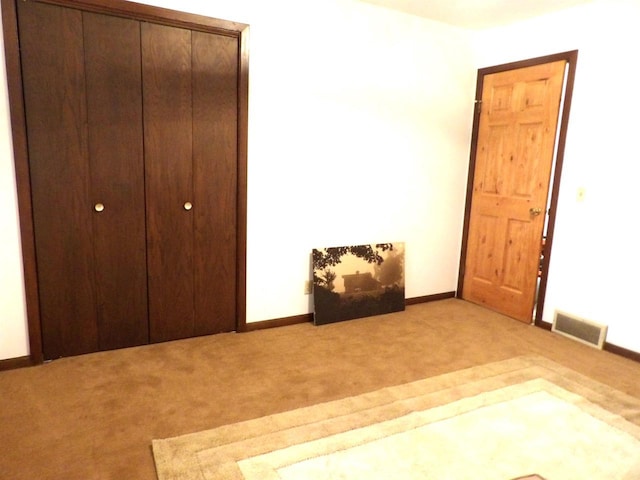 unfurnished bedroom featuring carpet floors, baseboards, visible vents, and a closet