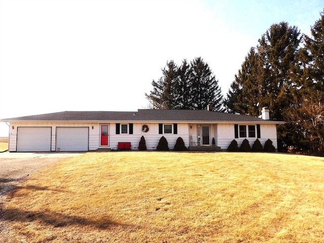 ranch-style home with a garage, driveway, a chimney, and a front lawn