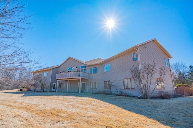 rear view of house featuring a deck and a yard