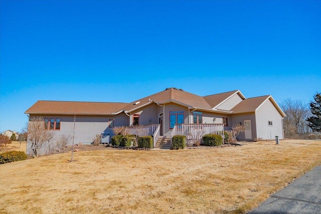 ranch-style home with a wooden deck and a front yard