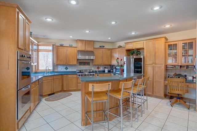 kitchen featuring light tile patterned floors, a kitchen island, under cabinet range hood, and stainless steel appliances