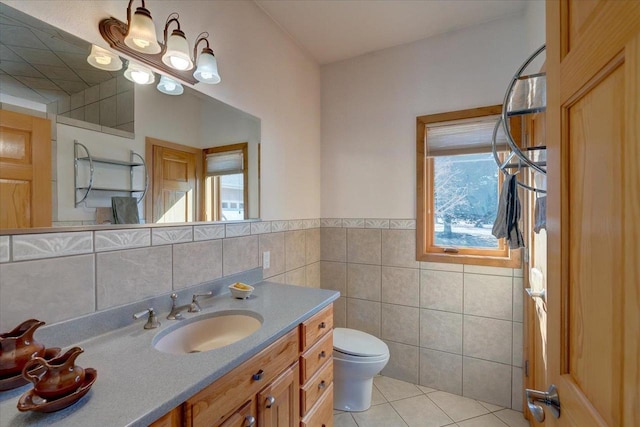 bathroom with tile patterned floors, toilet, vanity, and tile walls