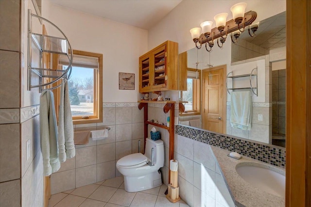 bathroom featuring a wealth of natural light, toilet, tile walls, and tile patterned floors