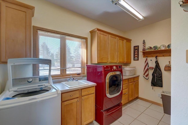 washroom with light tile patterned floors, baseboards, cabinet space, a sink, and washing machine and dryer