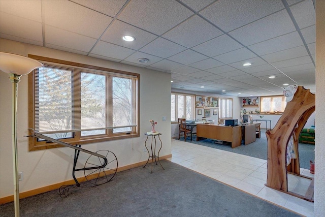 interior space with tile patterned flooring, a drop ceiling, recessed lighting, and baseboards