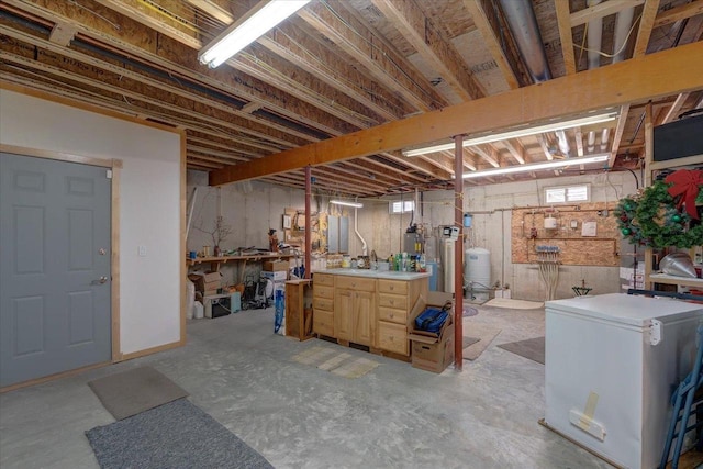 basement with plenty of natural light, a workshop area, and fridge