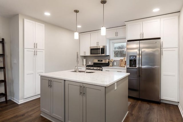 kitchen with white cabinets, backsplash, stainless steel appliances, and dark wood finished floors