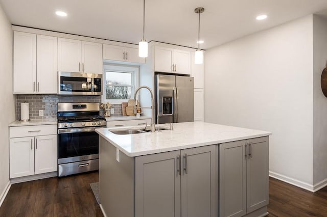 kitchen featuring tasteful backsplash, appliances with stainless steel finishes, dark wood-type flooring, white cabinetry, and a sink