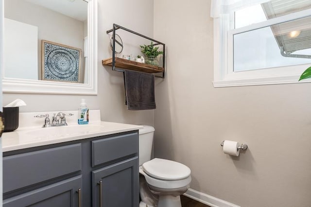 bathroom featuring vanity, toilet, and baseboards