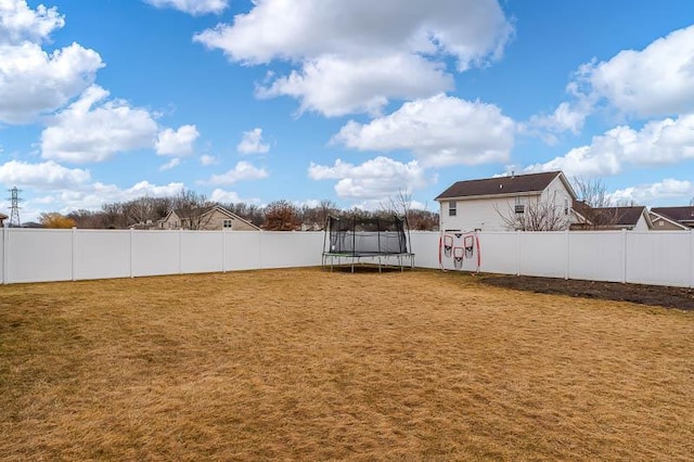 view of yard with a trampoline and a fenced backyard