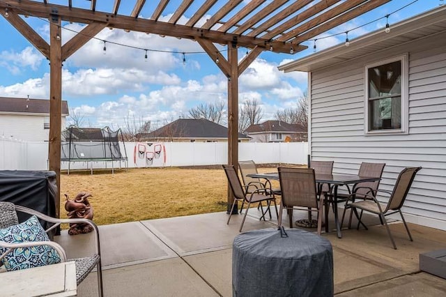 view of patio / terrace featuring a trampoline, outdoor dining area, a fenced backyard, and a pergola