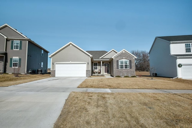 view of front of house featuring a garage, driveway, brick siding, and a front yard