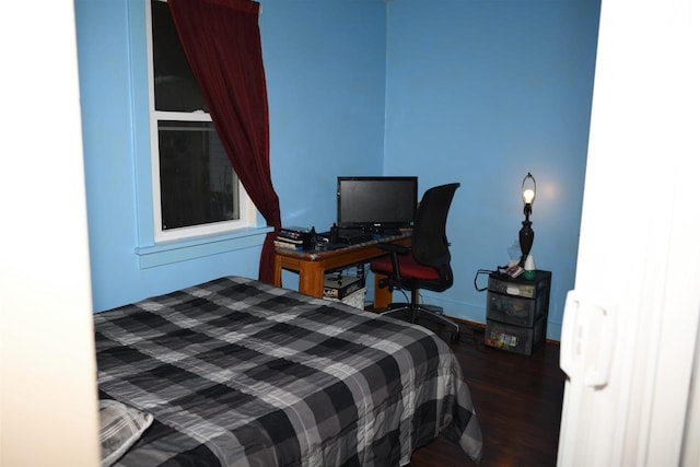 bedroom featuring baseboards and wood finished floors