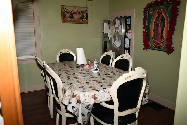 dining space featuring baseboards and wood finished floors