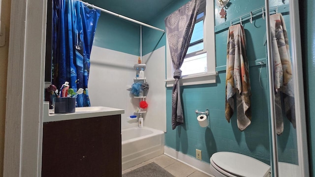 full bath featuring toilet, shower / bath combo with shower curtain, vanity, and tile patterned floors