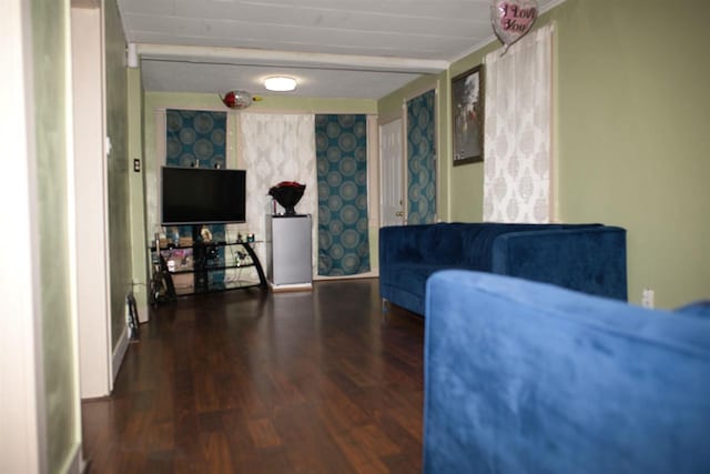 living area featuring baseboards, wood finished floors, and wallpapered walls