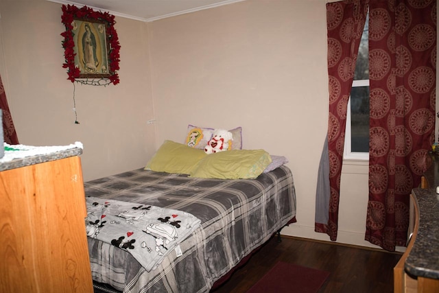 bedroom with ornamental molding and wood finished floors