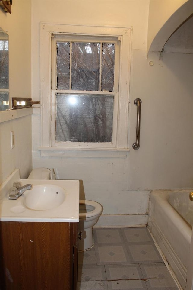 full bathroom with a bathtub, vanity, and toilet