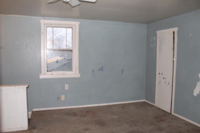 empty room featuring carpet, baseboards, and ceiling fan