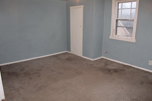 carpeted spare room featuring baseboards