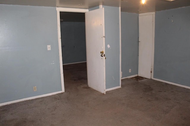 empty room featuring carpet and baseboards