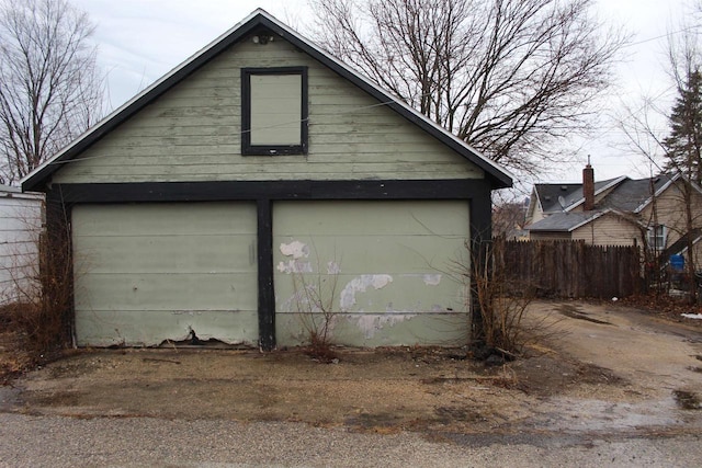 detached garage featuring fence