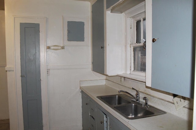 kitchen featuring electric panel, light countertops, and a sink