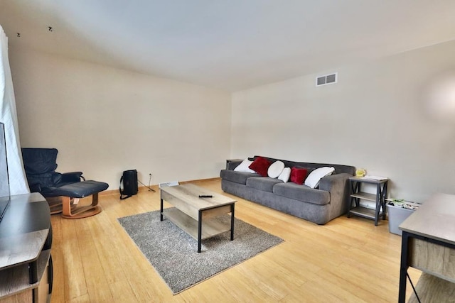 living area with visible vents and wood finished floors