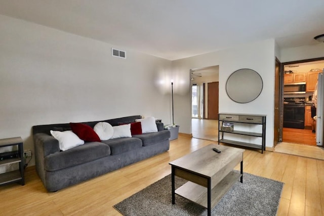 living room with light wood-type flooring and visible vents