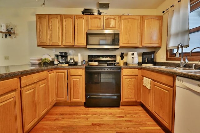 kitchen featuring black range with electric cooktop, white dishwasher, a sink, light wood-type flooring, and stainless steel microwave