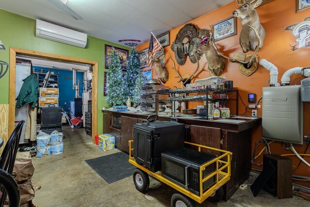 miscellaneous room featuring an AC wall unit, a workshop area, and concrete floors