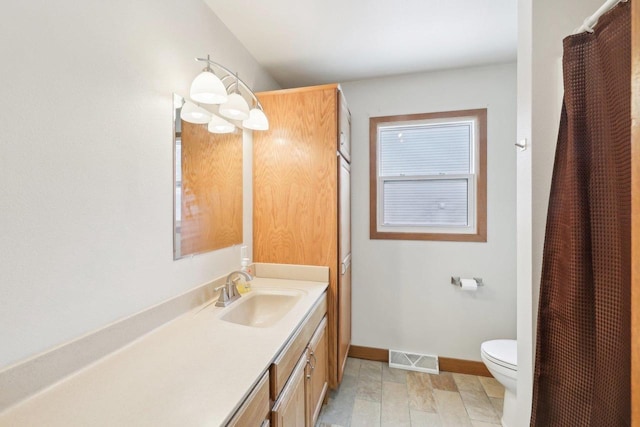 full bath featuring toilet, baseboards, visible vents, and vanity